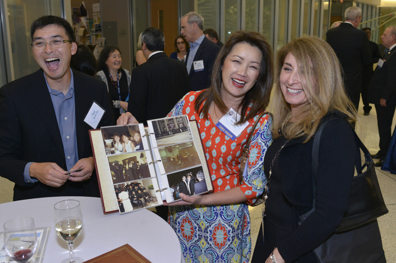 Silver Dragons (those who graduated 25 years ago) flip through old photos at their 25-year reunion reception.